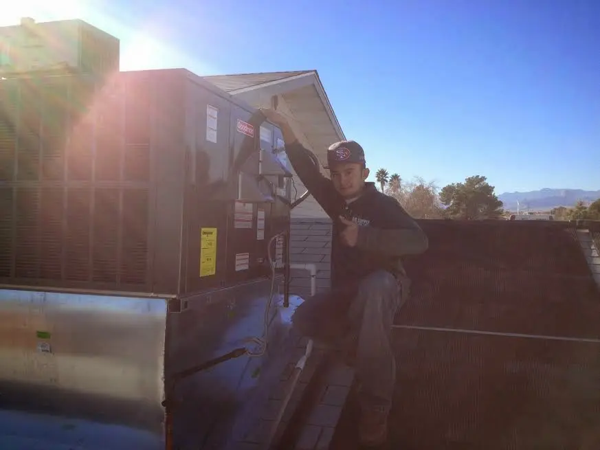 HVAC technician performing Heat Pump Repair on a rooftop unit in Willard