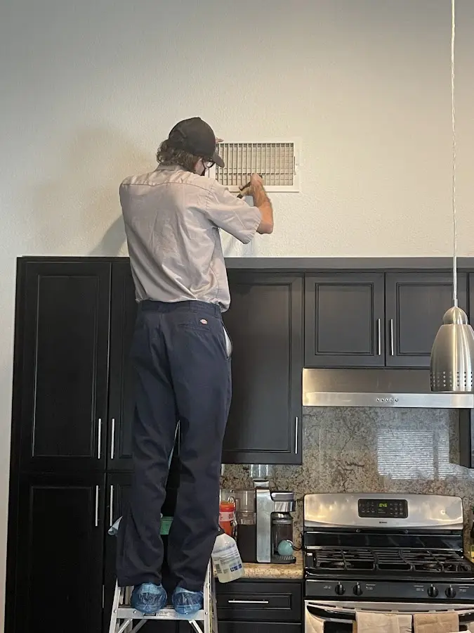 Technician inspecting an air vent during HVAC service in Willard